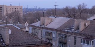 赫鲁晓夫的旧高层建筑的瓦片屋顶和生锈的卫星天线
