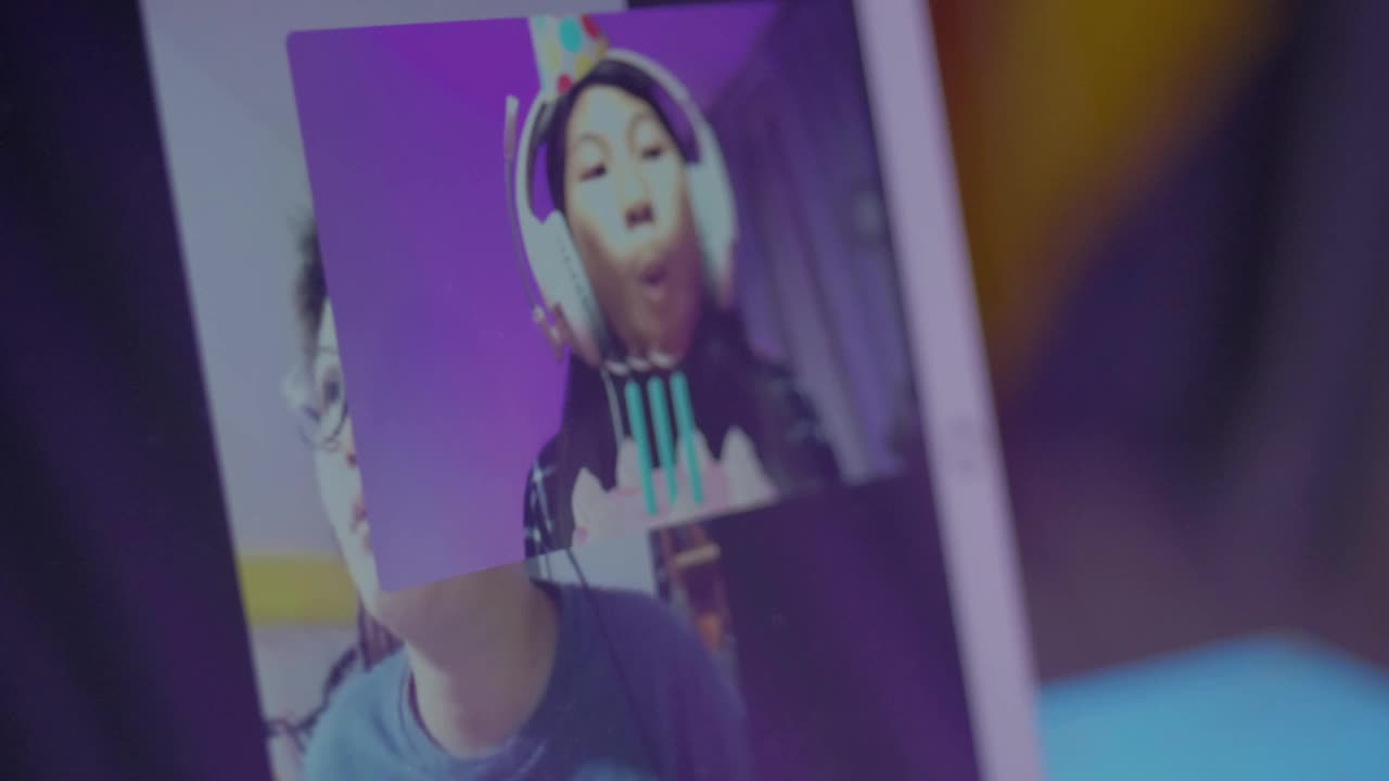 亚洲女学生在家里用数码平板电脑与老师进行视频通话，以Led灯为背景，社会距离的生活理念。