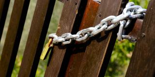 棕色木栅栏，金属链和黄色挂锁