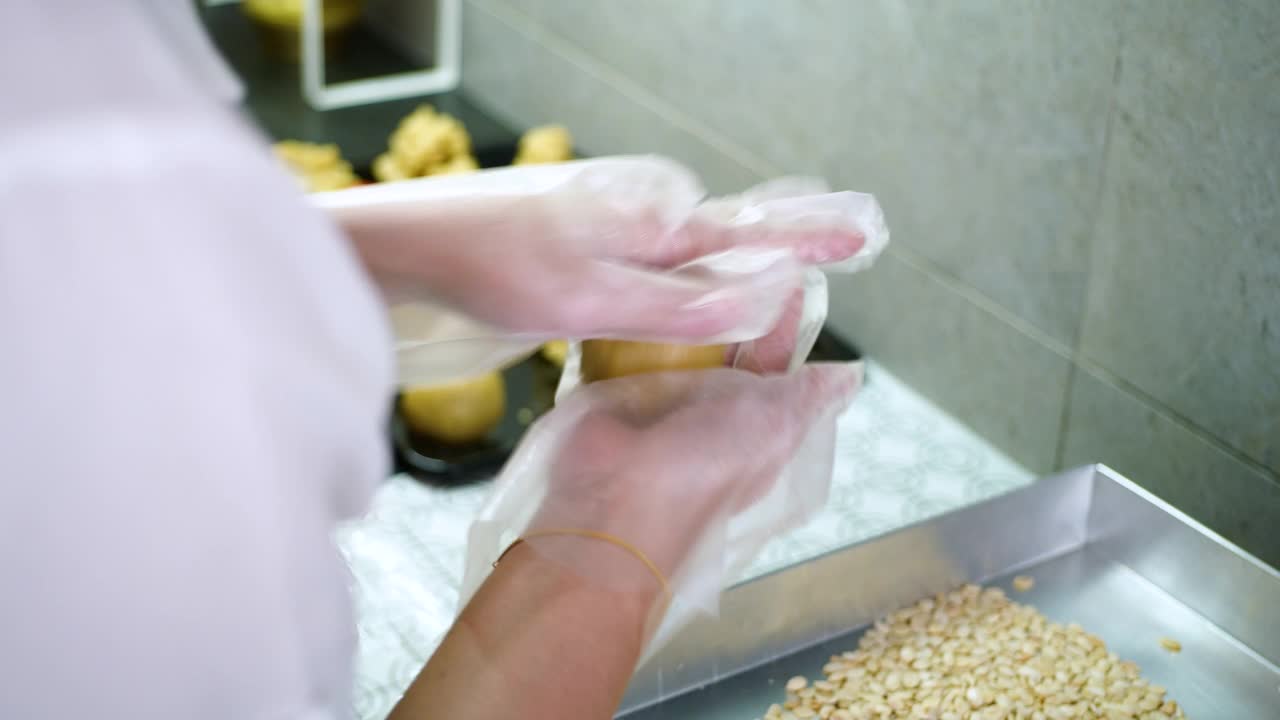 亚洲妇女在厨房制作月饼面团