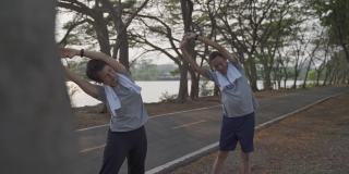 快乐活跃的老年夫妇锻炼和伸展在傍晚日落公园。笑脸活跃的亚洲老年情人一起户外活动分享美好时刻。健身二人在公园成熟锻炼。