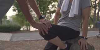 资深亚洲夫妇脚踝受伤事故照顾爱人。成熟男人用手按摩女人的腿和膝盖以减轻疼痛。肌腱和肌肉的急救治疗。照顾老年人的关系。