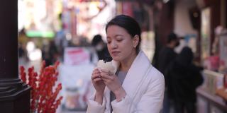 下班后在唐人街吃蒸猪肉包的年轻女子