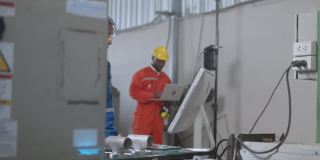 工程师合作两名专家男女技术员维护检查继电器机器人系统与平板电脑控制质量操作过程工作重工业4.0制造工厂
