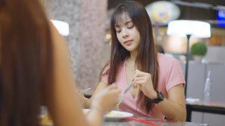 亚洲年轻的朋友，美女一起在餐厅吃饭。他们愉快地聊天，快乐地吃着食物。在自助餐厅的年轻人聚会。视频素材模板下载