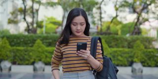 亚洲女人用智能手机走路