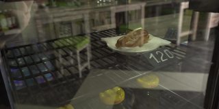 糖果店陈列橱窗上有牛角面包、蛋糕和松饼，背景