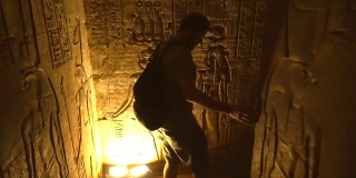 一个年轻人正在参观阿斯旺市附近的Edfu寺庙的隧道。埃及。飞机从后面跟着。在尼罗河河畔的Edfu城，希腊罗马建筑，献给荷鲁斯