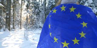 在冬天的气氛中，女孩拿着欧盟的旗帜