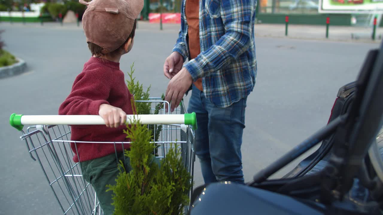 在花园中心购物后，家人把植物放在停车场的车里