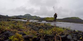 一个年轻人从冰岛的兰德马纳洛格尔出发，在54公里的长途跋涉中穿过山谷中的一条河