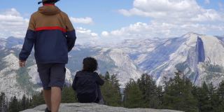 一对夫妇从约塞米蒂国家公园的冰川点看公园和瀑布。美国加利福尼亚州