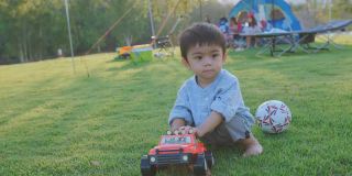 小男孩在草坪上玩玩具。