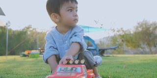 小男孩在草坪上玩玩具。