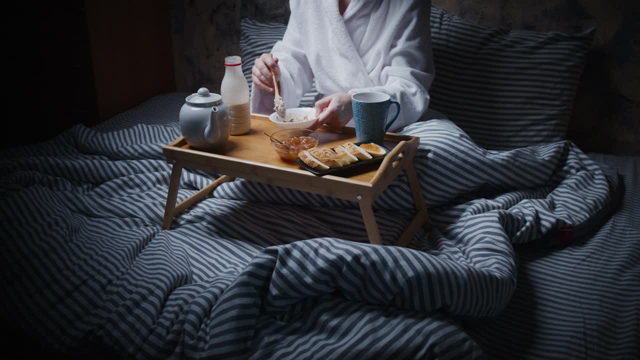 一个面目全非的女人在床上吃早餐