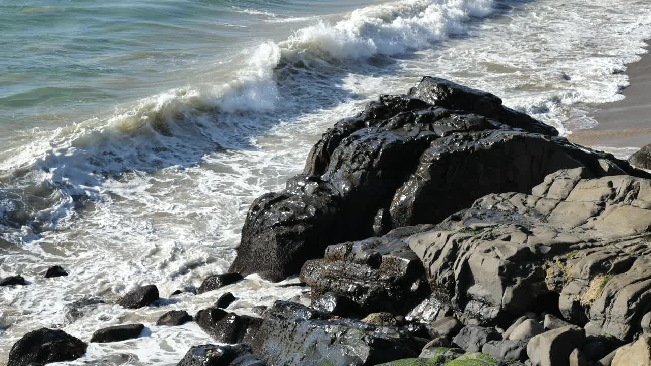 巨浪冲击着多岩石的海岸线