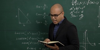 年轻的亚洲教师男子教授视频会议与学生。男性印度教师在课堂上通过在线课程培训数学。