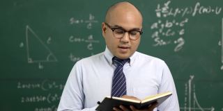 年轻的亚洲教师男子教授视频会议与学生。男性印度教师在课堂上通过在线课程培训数学。