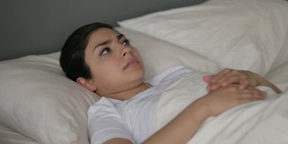 年轻的印度妇女头痛躺在床上
