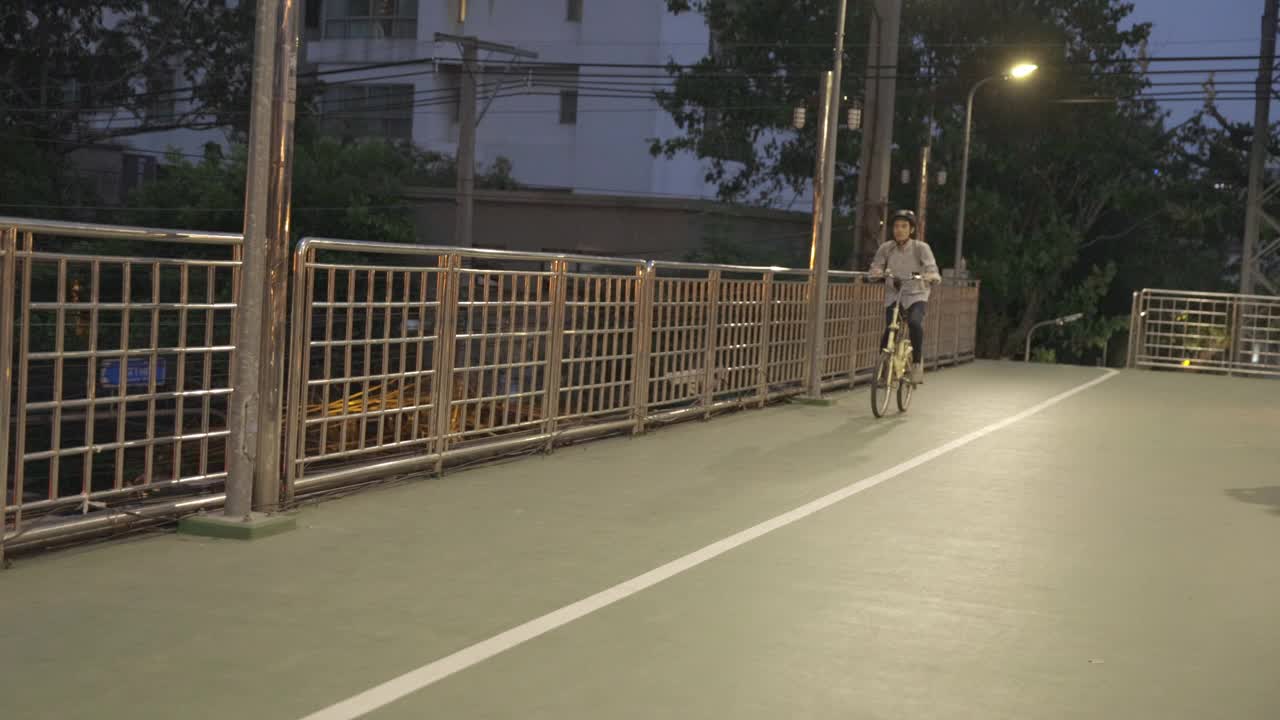 亚洲商人在立交桥上骑自行车