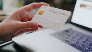 有魅力的女人拿着信用卡在网上付款，同时在笔记本电脑上网上购物视频素材模板下载