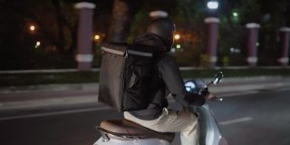 晚上在城市里骑摩托车的快递员