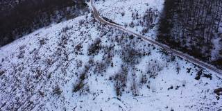 用无人机拍摄白雪覆盖的森林和乡村道路