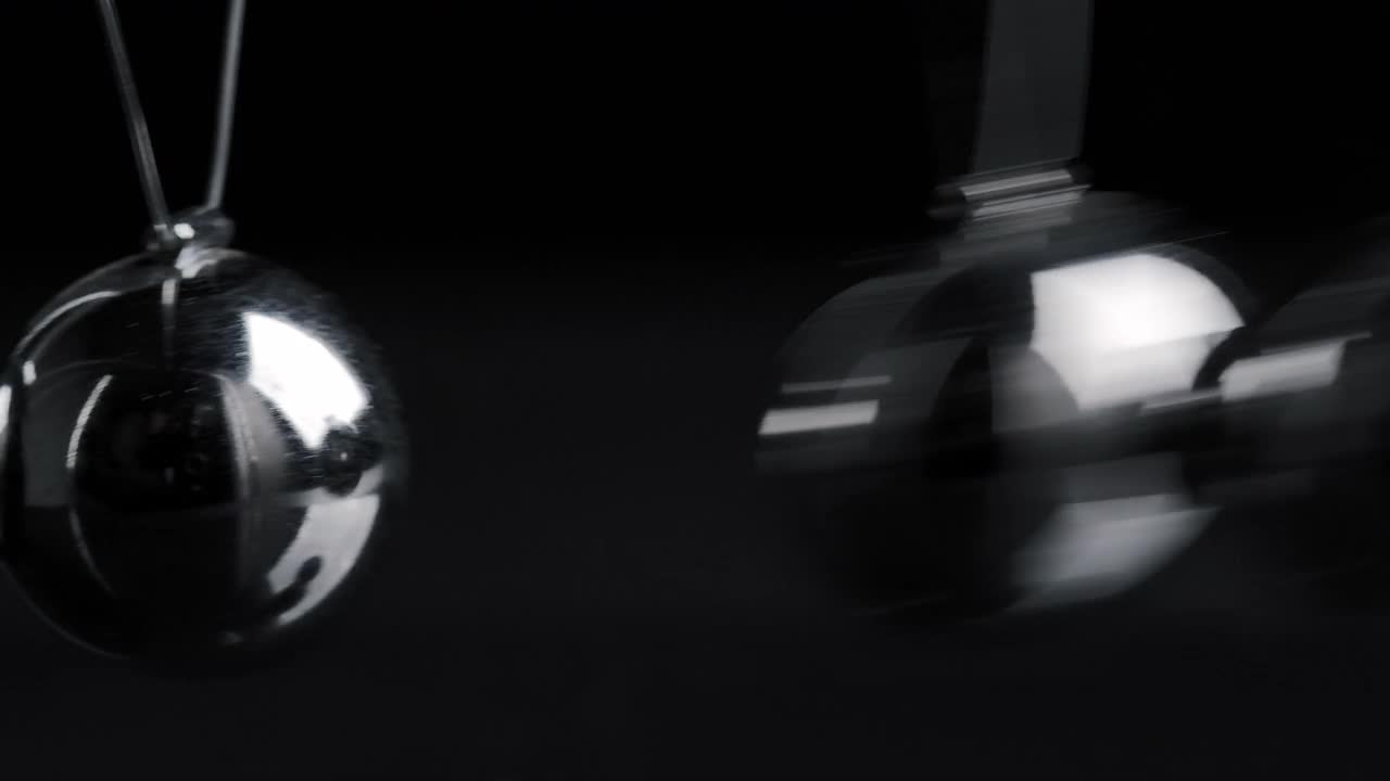 悬挂铬牛顿球在黑色背景运动的镜头