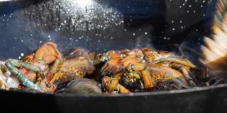 在煎锅中煎炸打开的龙虾以准备米饭或海鲜饭