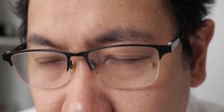 一个戴眼镜的男人的近距离检查他的视力，模糊的视力问题