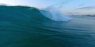 日出时海浪冲上岸来。大西洋的波浪在巴西圣卡塔琳娜岛的海岸冲散