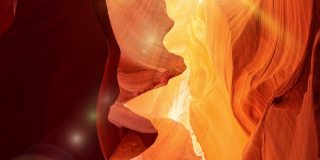 在美国亚利桑那州的羚羊峡谷，红色和橙色的墙壁。放大拍摄羚羊峡谷与光线的正午太阳和眩光