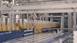 橙汁玻璃瓶在生产线上移动视频素材模板下载