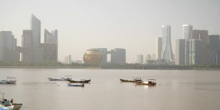 阳光明媚的一天，杭州市区著名的现代建筑，滨江海湾的船只，慢镜头全景4k中国