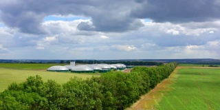 田间沼气厂。有机农场在黑暗多云的天空下被夏日的绿色大自然包围着。沼气是通过发酵生物质而产生的。