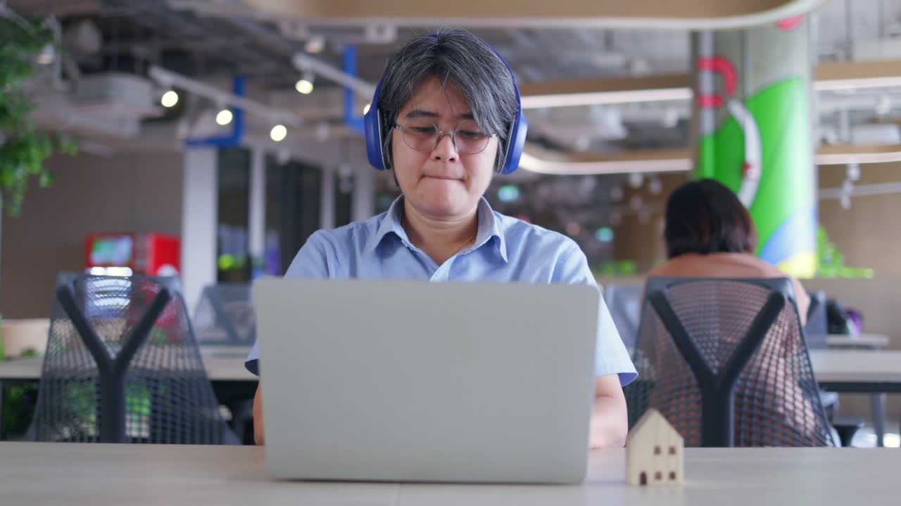 亚洲商务女性戴着耳机坐在共同工作空间的商务咨询会议。营销策划。在网络空间里用免费的Wi-Fi工作。无线技术概念