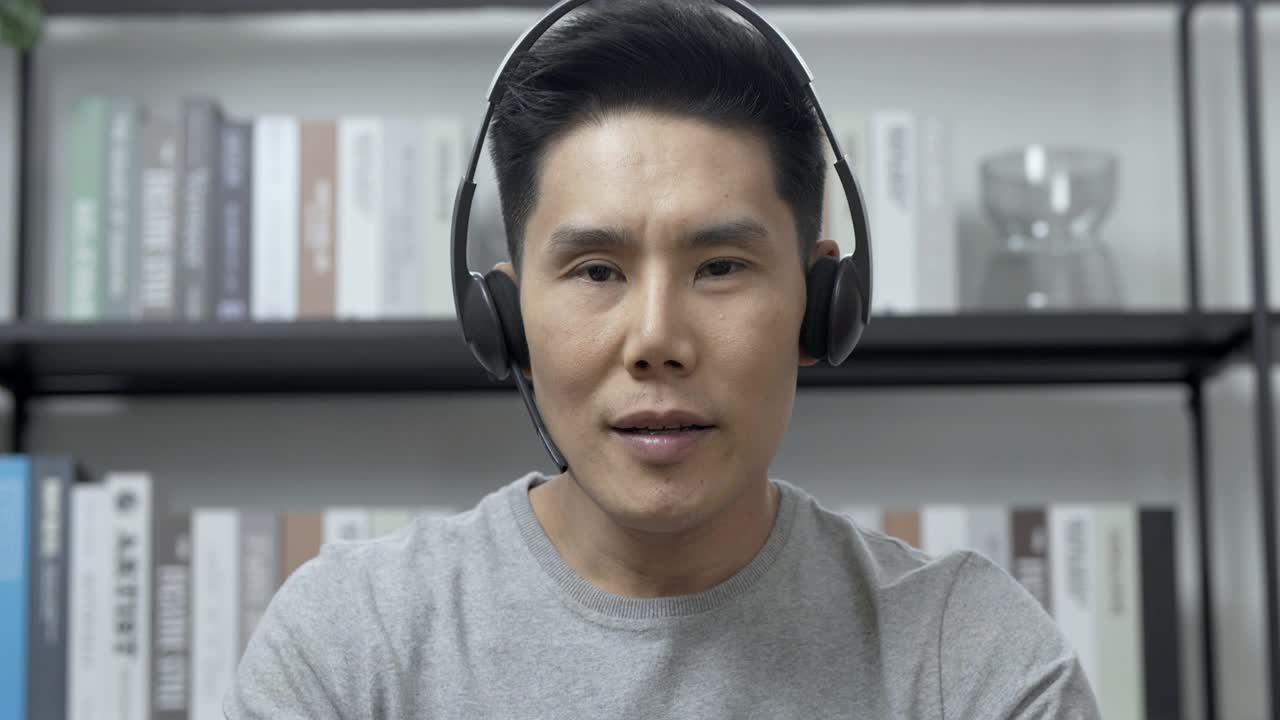 一名男子戴着耳机对着镜头说话的大头照。