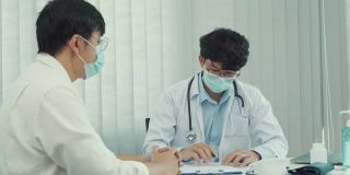 在疫情期间，医生们戴着口罩向患者解释治疗方法。