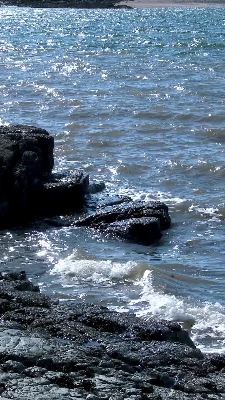 阳光明媚的春日，海浪拍打着岩石