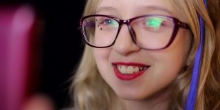 儿童科技:一个戴着粉色眼镜的女孩用着智能手表。
