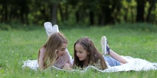 在一个阳光明媚的夏日，两个可爱的小妹妹在草地上玩耍