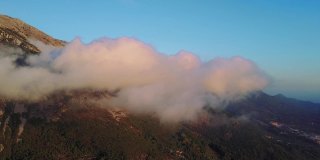 相机在云中移动。梦幻般的日出在岩石山顶上，看到雾气蒙蒙的山谷。