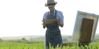 在田野里用油画颜料作画的女艺术家