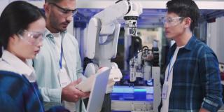 技术假肢机器人手臂是由两位专业开发工程师测试在一个高科技研究实验室与现代未来的设备。男性和女性比较个人电脑上的数据。