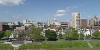 首都地区绿地和萨斯奎哈纳风景展望滨水公园在哈里斯堡，宾夕法尼亚州，与远观城市到州议会行政大楼。无人机拍摄的带有上升摄像机运动的航拍视频。