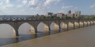 历史悠久的胡桃街铁路桥，市场街桥，以及其他横跨萨斯奎哈纳河的桥梁，在宾夕法尼亚州哈里斯堡市中心的远处可以看到。无人机拍摄的带有上升摄像机运动的航拍视频。