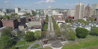 首都地区绿地和萨斯奎哈纳风景展望的航拍，在哈里斯堡滨水公园，宾夕法尼亚州，从城市到州议会行政大楼的远景。无人机拍摄的航拍视频。