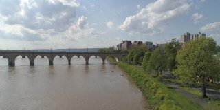 历史悠久的胡桃街铁路桥，市场街桥，以及其他横跨萨斯奎哈纳河的桥梁，在宾夕法尼亚州哈里斯堡市中心的远处可以看到。带有平移和上升摄像机运动的无人机拍摄的航拍视频。