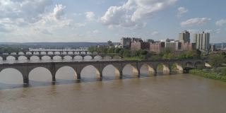 历史悠久的胡桃街铁路桥，市场街桥，以及其他横跨萨斯奎哈纳河的桥梁，在宾夕法尼亚州哈里斯堡市中心的远处可以看到。无人机制作的航空视频与电影复杂的平移和宽轨道摄像机运动。