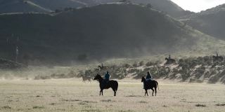 牛仔和马在犹他州山坡上奔跑的广角视频
